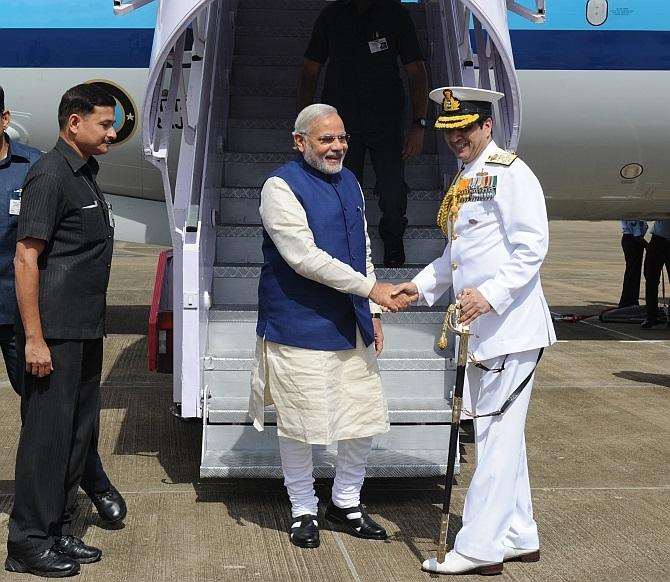 The prime minister is received by naval chief Admiral Robin K Dhowan.