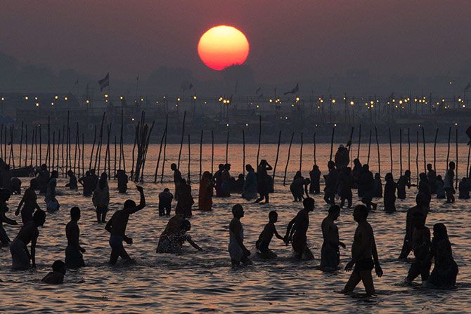 In the backdrop of the setting sun, men take a dip in the Sangam in Allahabad. Photographs: Daniel Berehulak/Getty Images