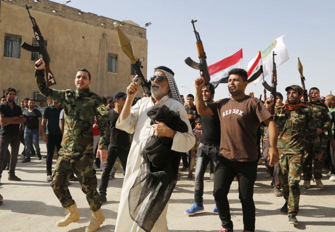 Volunteers, who have joined the Iraqi army to fight against the militants, stage a parade in the streets in Baghdad's Sadr city.