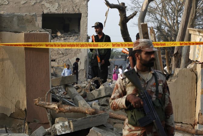 Security forces keep guard at the site of the Crime Investigation Department building the morning after it was levelled by a suicide bomb attack in Karachi in November 12, 2010