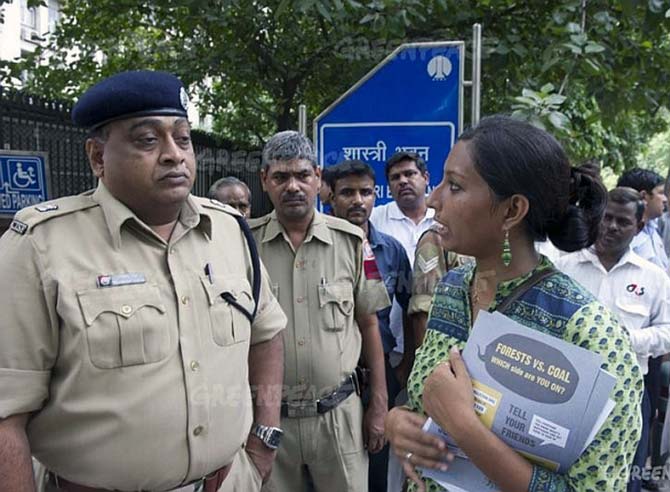 Greenpeace campaigner Priya Pillai talks to security officials during a protest against the coal ministry