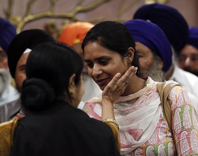 A relative of an Indian worker who has been kidnapped in Iraq, is being comforted by External Affairs Minister Sushma Swaraj after their meeting in New Delhi