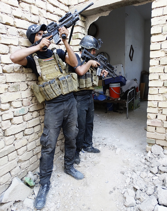 Members of the Iraqi Special Operations Forces take their positions during a patrol looking for militants, the Islamic State of Iraq and Syria, explosives and weapons in a neighbourhood in Ramadi