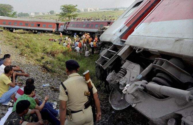 Police stand guard at the derailment spot as NDRF officials tried to look for other passengers