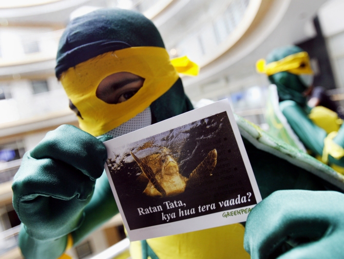 A Greenpeace activist displays a card that reads 'Ratan Tata, what happened to your promise?' during a demonstration in front of the office of insurance firm, Tata AIG in Mumbai.
