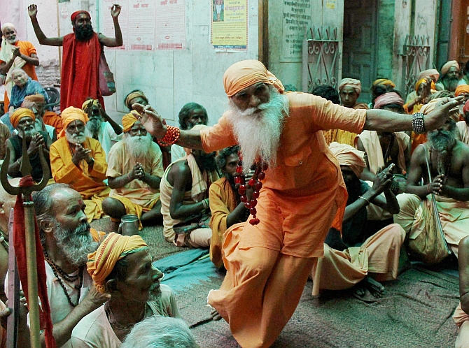 A sadhu dances while others clap ahead of the pilgrimage 