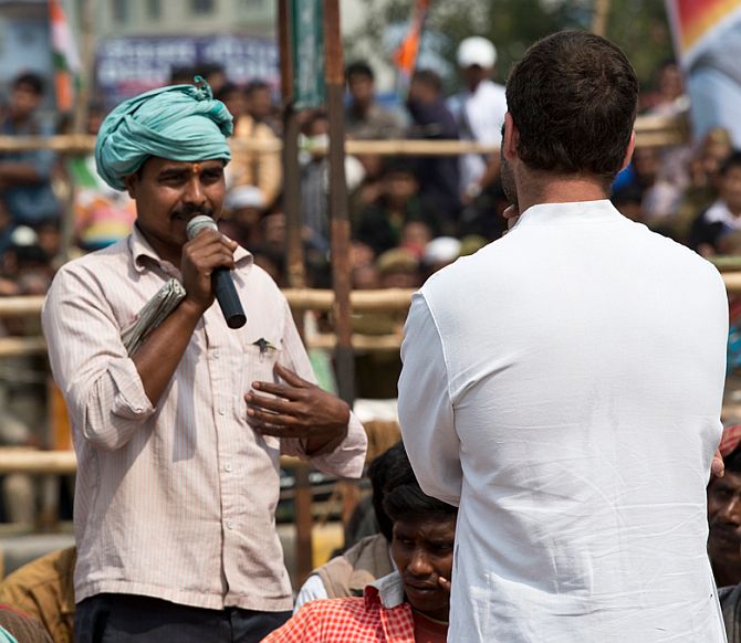 A rickshaw-puller interacts with Rahul Gandhi outside the Cantonment Railway Station in Varanasi