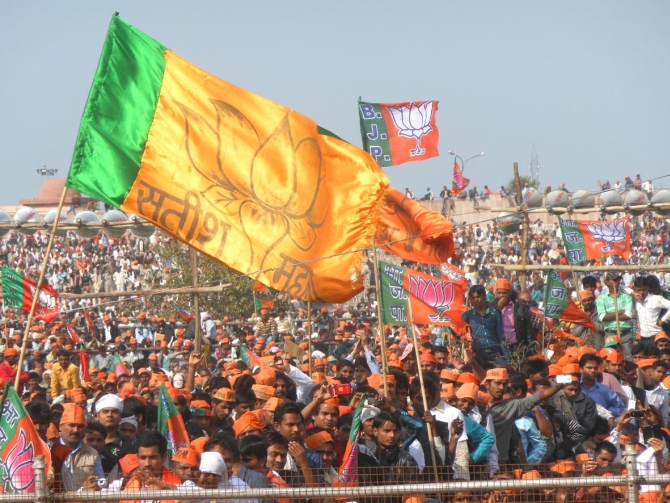 BJP supporters wave flags as they listen to Modi's speech at the Lucknow rally