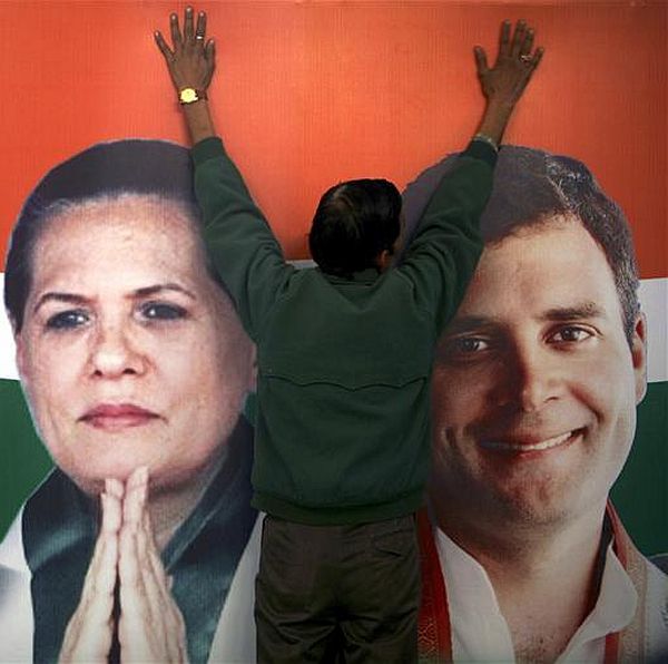 A worker installs a hoarding containing pictures of Congress president Sonia Gandhi and Rahul Gandhi at the party's headquarters in Jammu