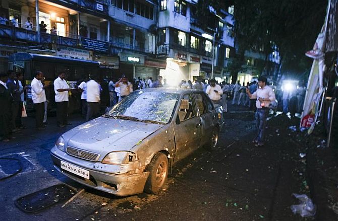 A car is seen damaged at the site of a bomb explosion in the Dadar area of Mumbai July 13, 2011.