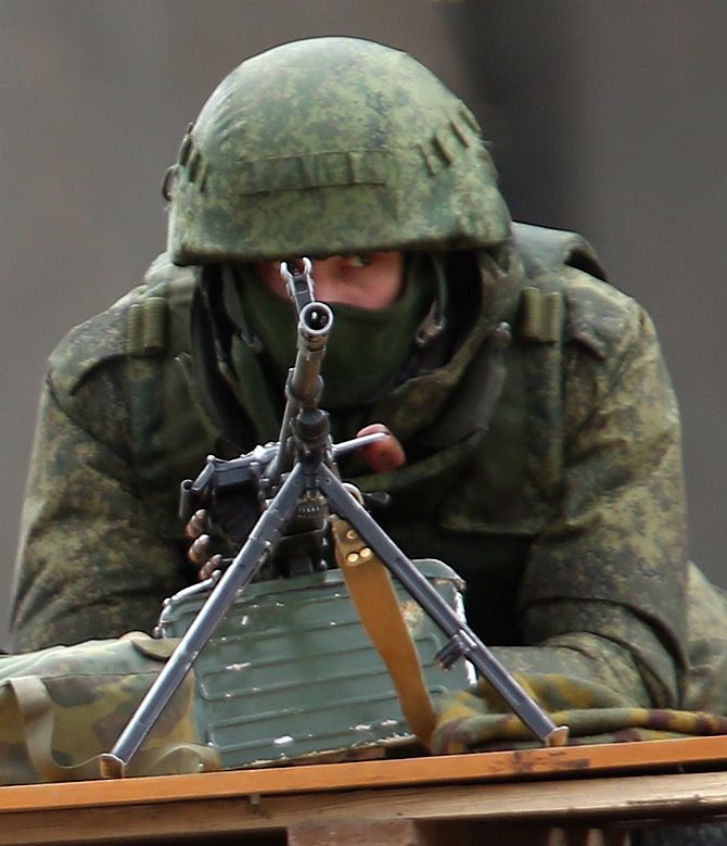 A soldier without identifying insignia mans a machine gun outside the Crimean parliament building shortly after several dozen soldiers took up positions