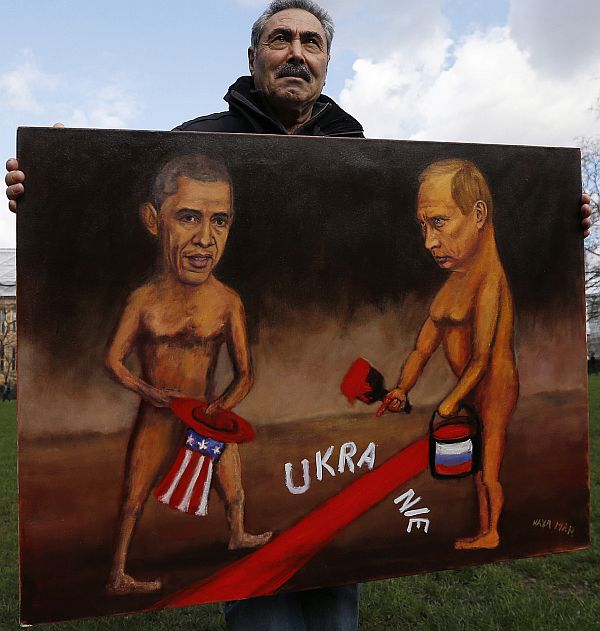 Artist Kaya Mar holds a satirical painting depicting US President Barack Obama and Russia's President Vladimir Putin in Ukraine.