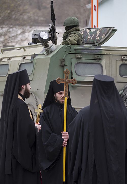 Orthodox monks besides a soldier in a Russian army vehicle in the Crimean town of Balaclava.