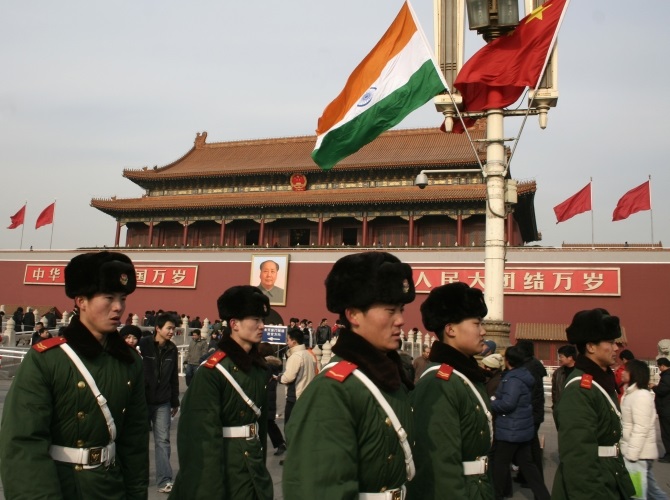 Chinese paramilitary policemen walk past an Indian flag in front of Tiananmen Gate in Beijing 