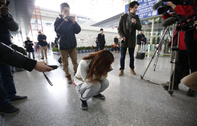  Journalists attempt to interview a woman who is the relative of a passenger on Malaysia Airlines flight MH370