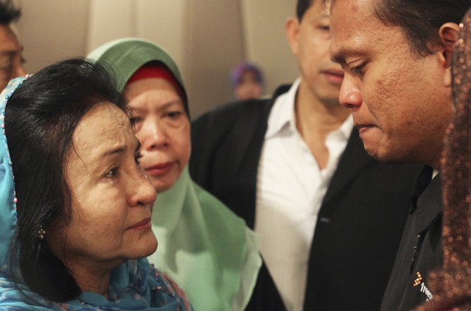 Rosmah Mansor (left), wife of Malaysian Prime Minister Najib Razak, cries with family members of passengers on the missing Malaysia Airlines flight MH370, at a hotel in Putrajaya