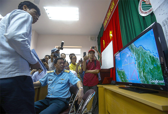 Deputy commander of Vietnam Air Force Do Minh Tuan looks at a map on a TV screen during a news conference about their mission