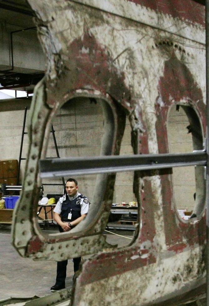 A member of the Royal Canadian Mounted Police stands watch near the wreckage of Air India Flight 182 that was bombed over the Atlantic in 1985 as it sits in an undisclosed location in Vancouver, British Columbia