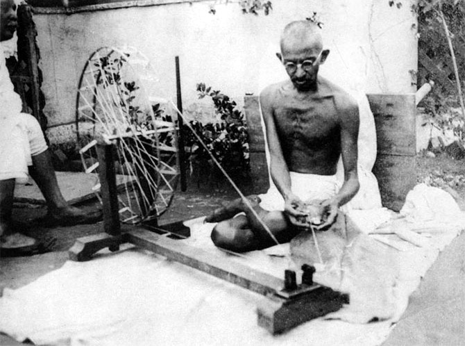 Mahatma Gandhi with his spinning wheel.