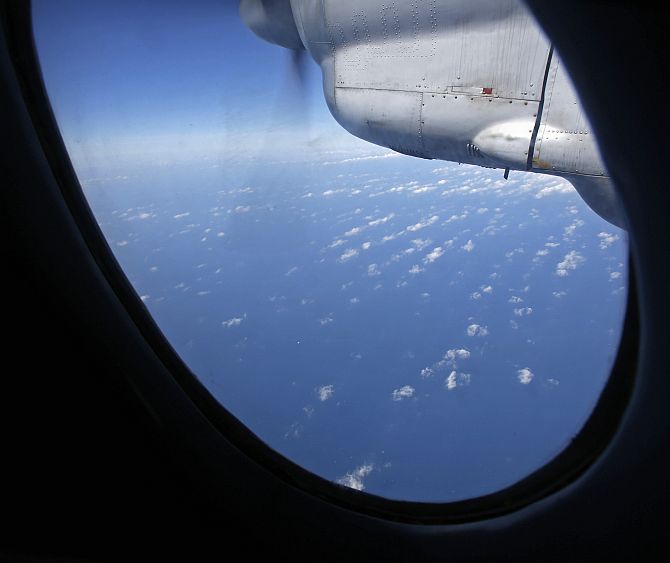 Clouds hover outside the window of a Vietnam Air Force aircraft AN-26 during a mission to find the missing Malaysia Airlines flight MH370