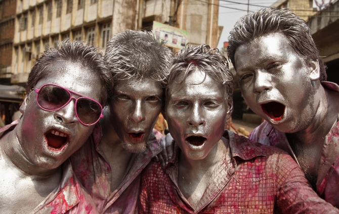 People daubed in colours dance as they celebrate Holi in Guwahati.