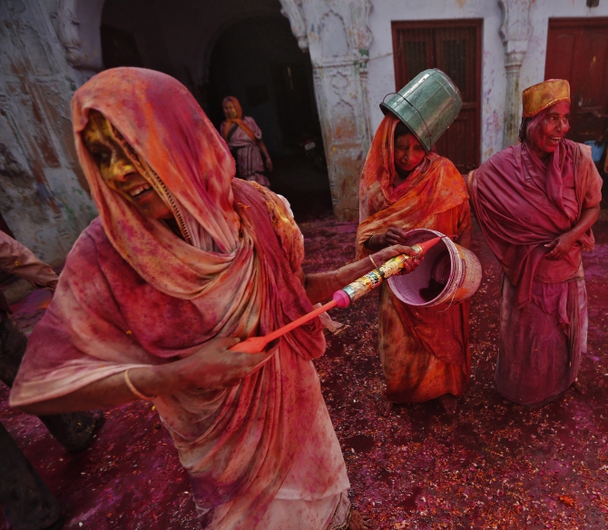 Widows daubed in colours as they take part in Holi celebrations organised by non-governmental organisation Sulabh International at a widows' ashram in Vrindavan