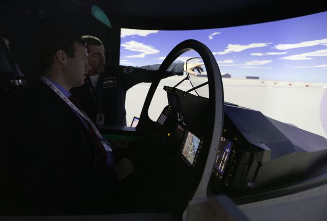 A visitor is briefed on a flight simulator at the Bahrain International Airshow held at the Sakhir Air Base, south of Manama