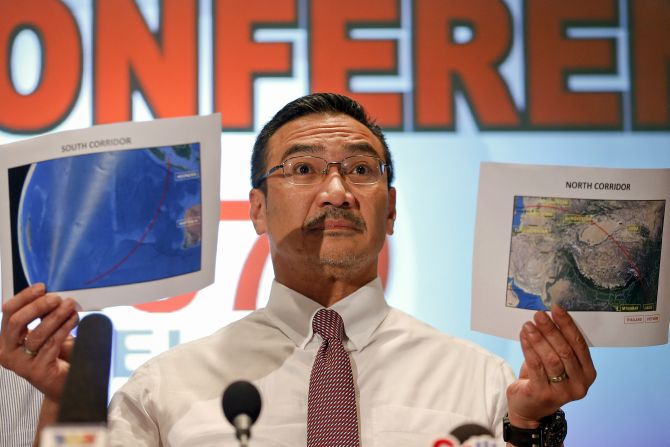 Malaysia's acting Transport Minister Hishammuddin Hussein shows two maps with corridors of the last known possible location of the missing Malaysia Airlines MH370 plane as he addresses reporters at the Kuala Lumpur International Airport 