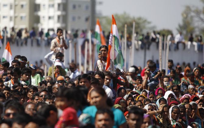 A Congress supporter takes a picture while listening to Rahul Gandhi during a rally in Bardoli, Gujarat