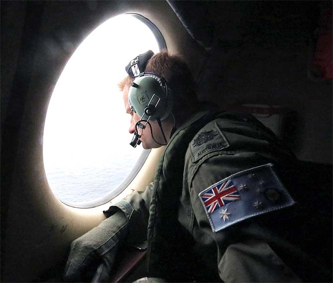 Royal Australian Air Force Warrant Officer Michal Mikeska looks out of a RAAF C-130J Hercules aircraft as it flies over the southern Indian Ocean during the search for the missing Malaysian Airlines flight MH370
