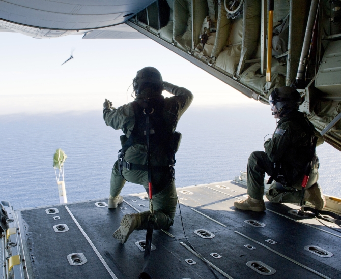 Royal Australian Air Force Loadmasters, Sergeant Adam Roberts (L) and Flight Sergeant John Mancey, launch a 'Self Locating Data Marker Buoy' from a C-130J Hercules aircraft in the southern Indian Ocean during the search for missing Malaysian Airlines flight MH37