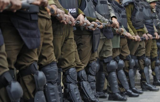 Policemen form a chain across a road to stop a protest march by workers of the People's Democratic Party in Srinagar.