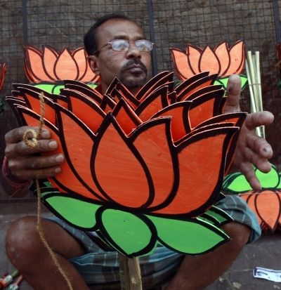A man carries cutouts of the BJP symbol