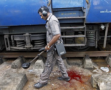 A member of the bomb disposal squad examines the area next to the Bangalore-Guwahati Kaziranga Express on which the explosions occurred.