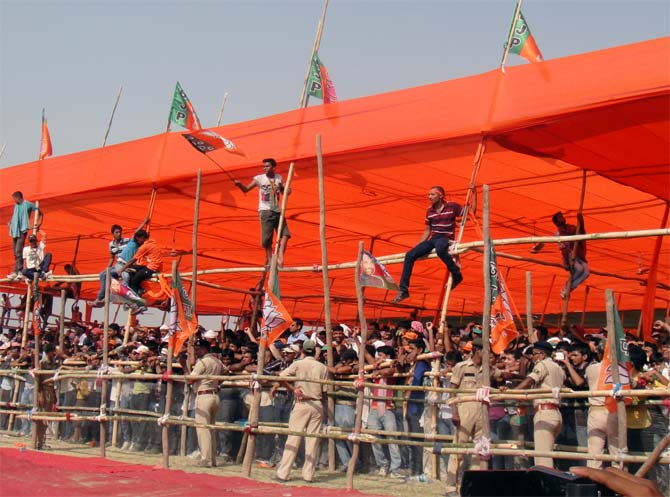 Enthusiastic supporters climb bamboo scaffolding to get a better view of Modi at the Chhapra rally.