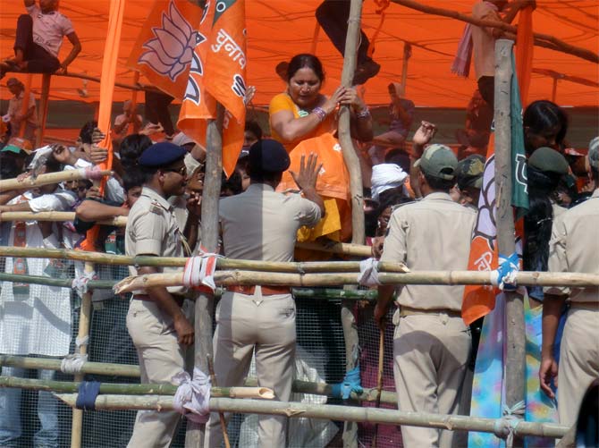 Women climb out of the enclosure to avoid being crushed by the men at the Modi rally in Chhapra, Bihar.