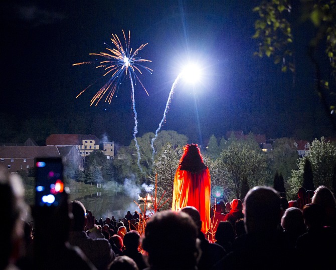 A man dressed as devil towers over revellers as they watch fireworks explode over a Walpurgisnacht pagan festival in the town of Stiege, in the Harz mountain region