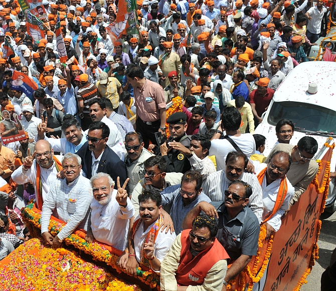 Narendra Modi and Amit Shah show the victory sing during a roadshow in Varanasi