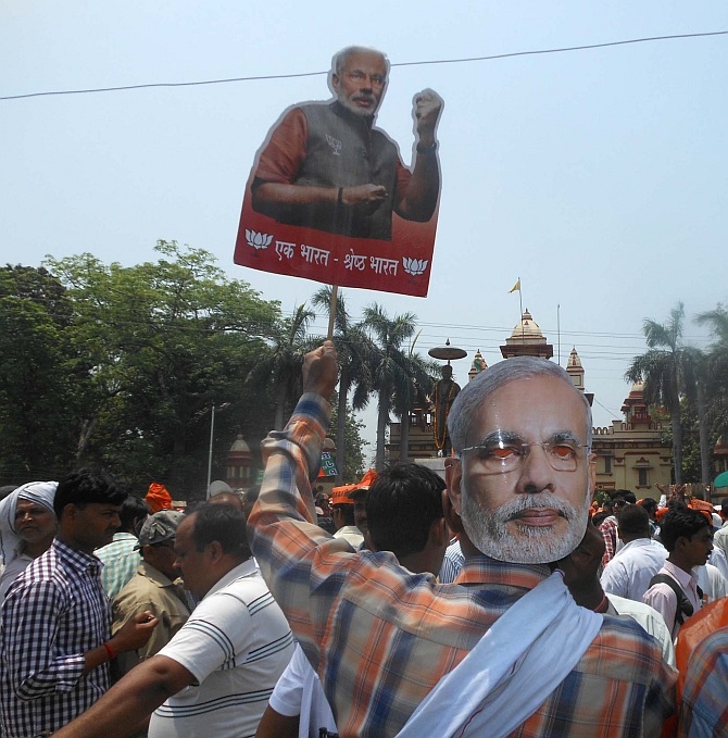 A BJP supporter wearing a Modi mask joins the protest outside BHU