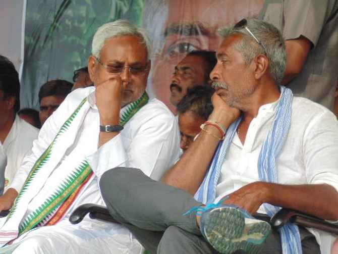Bihar Chief Minister Nitish Kumar speaks to Prakash Jha during a rally in West Champaran district