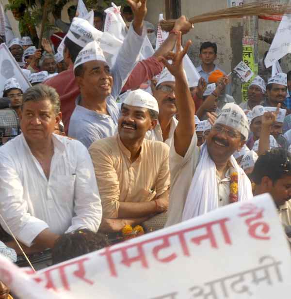AAP leader Arvind Kejriwal waves to supporters during a roadshow in Varanasi