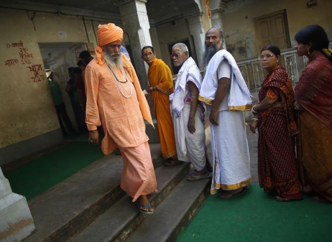 A sadhu walks out of a polling booth in Varanasi after casting his vote.