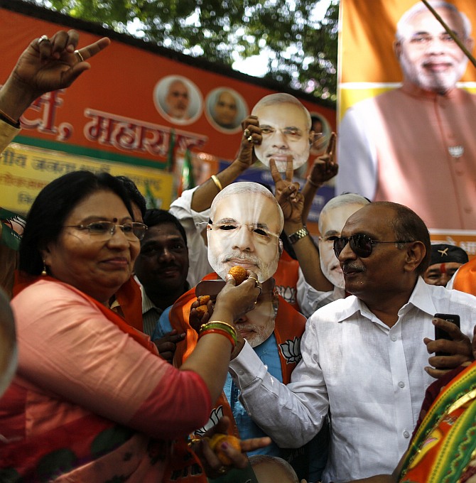 Supporters of the Bharatiya Janata Party hold up a mask of Narendra Modi in Mumbai 