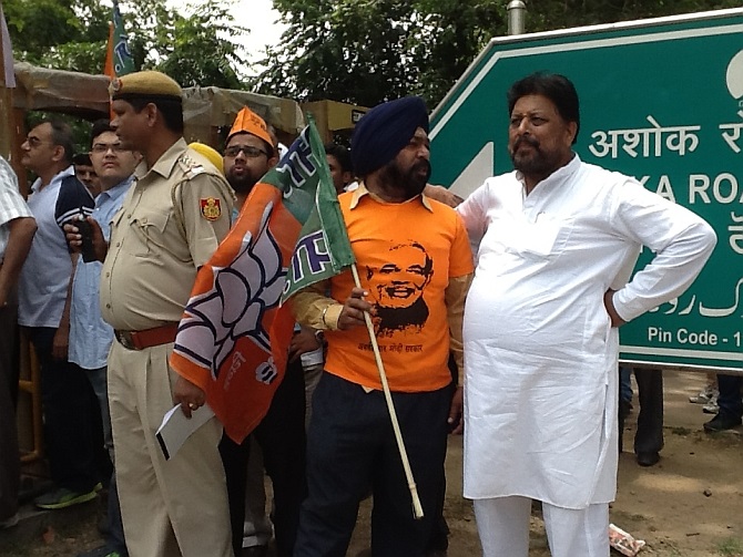 A BJP supoorter sporing a Modi tee-shirt and carrying the party flag at the roadshow
