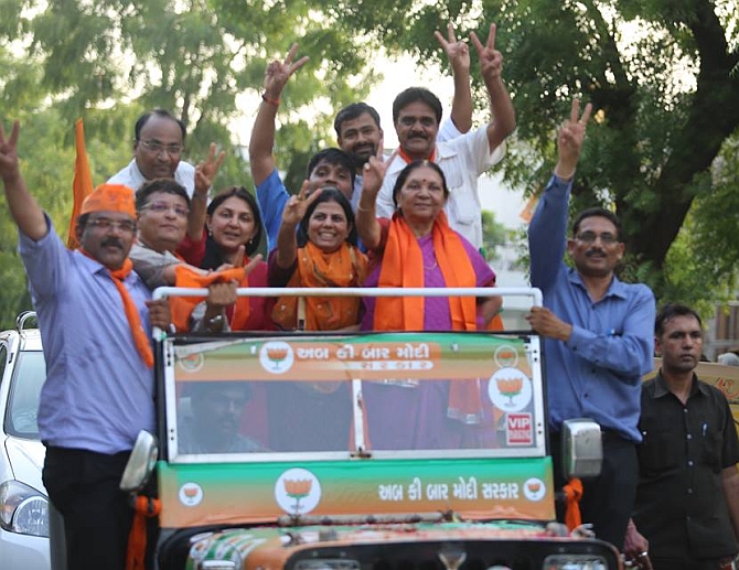 Anandiben shows the victory sign as she participates in a roadshow after the BJP win in the Lok Sabha polls