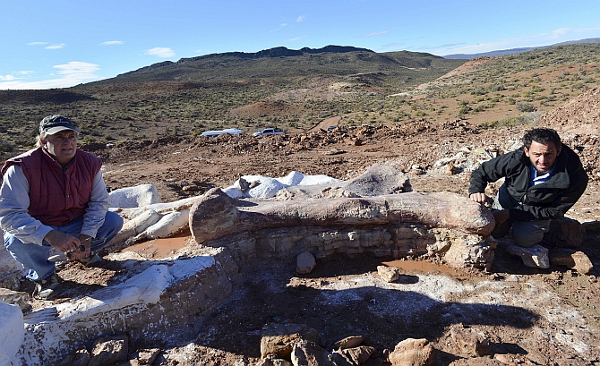 Paleontologists Jose Luis Carballido (right) and Ruben Cuneo pose next to the bones of a dinosaur at a farm in La Flecha, west of the Argentina's Patagonian city of Trelew