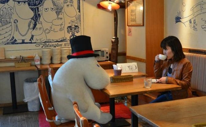 A diner sits with a stuffed toy at the Japanese cafe.