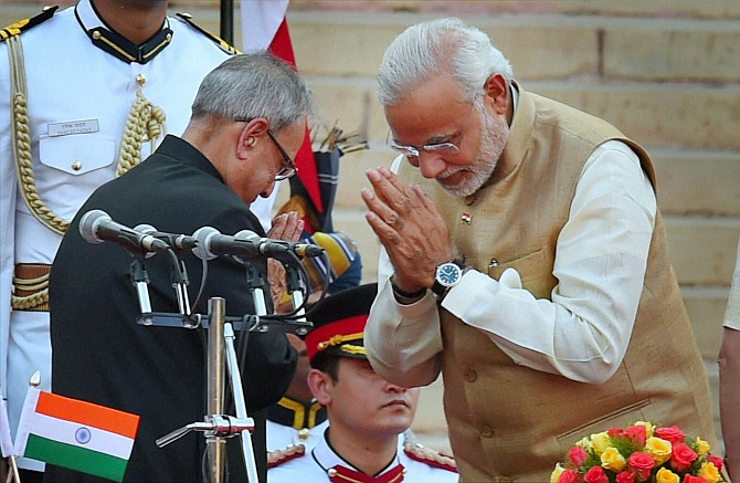 President Pranab Mukherjee greets Prime Minister Narendra Modi after administering him the oath at a ceremony at Rashtrapati Bhavan in New Delhi