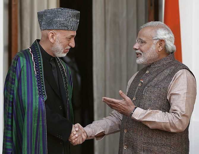 Modi shakes hands with Afghanistan's President Hamid Karzai before start of their meeting in New Delhi 