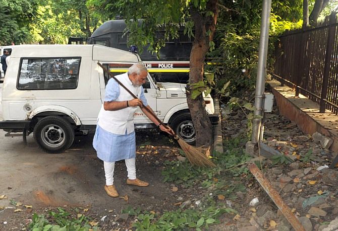 Prime Minister Narendra Modi cleans a street.